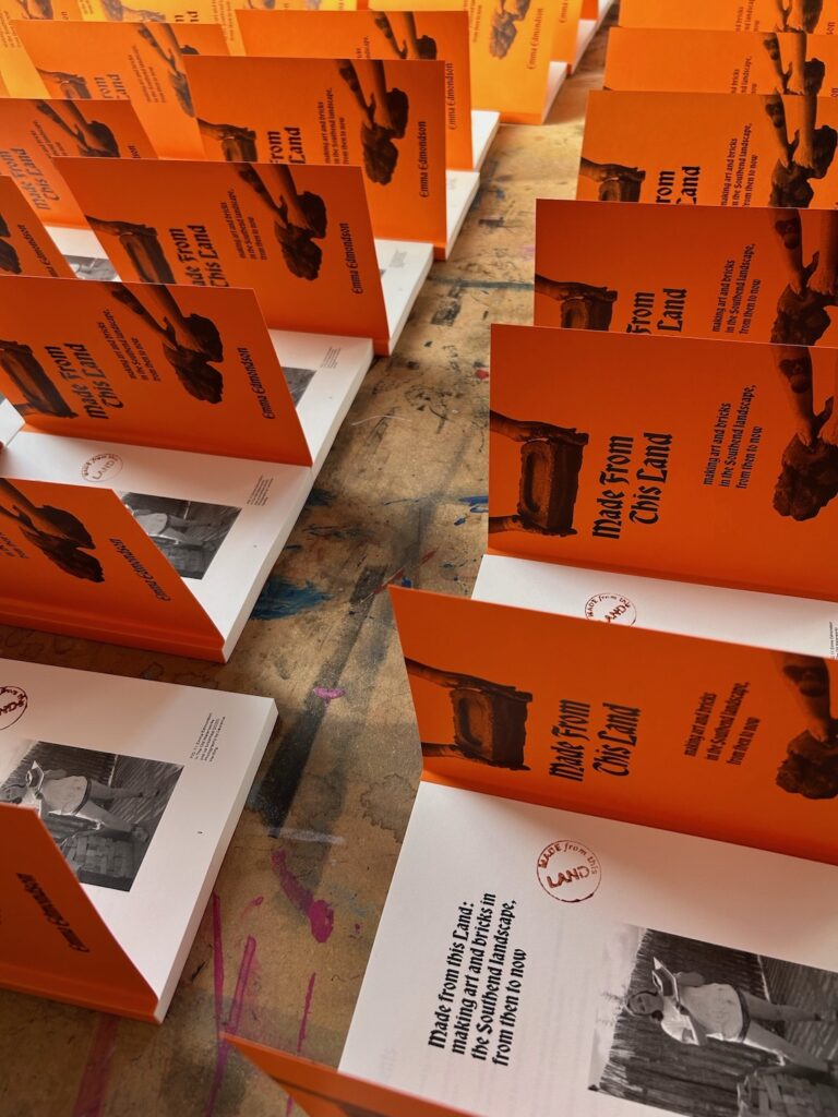 Copies of the Made From This Land publication laid out in a display with the covers open 